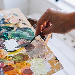 Peintre déposant de la peinture blanche sur sa palette